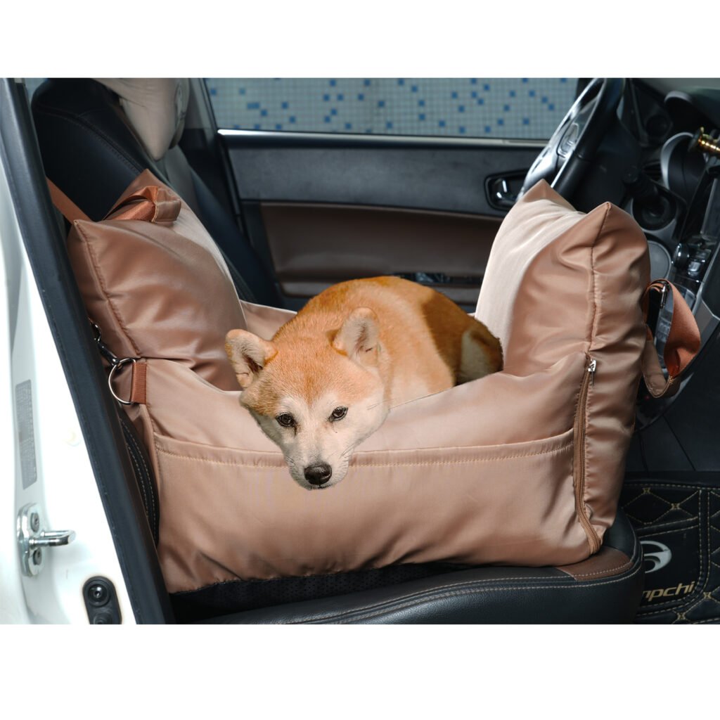 A dog sitting comfortably on a waterproof hammock-style car seat protector during a road trip.